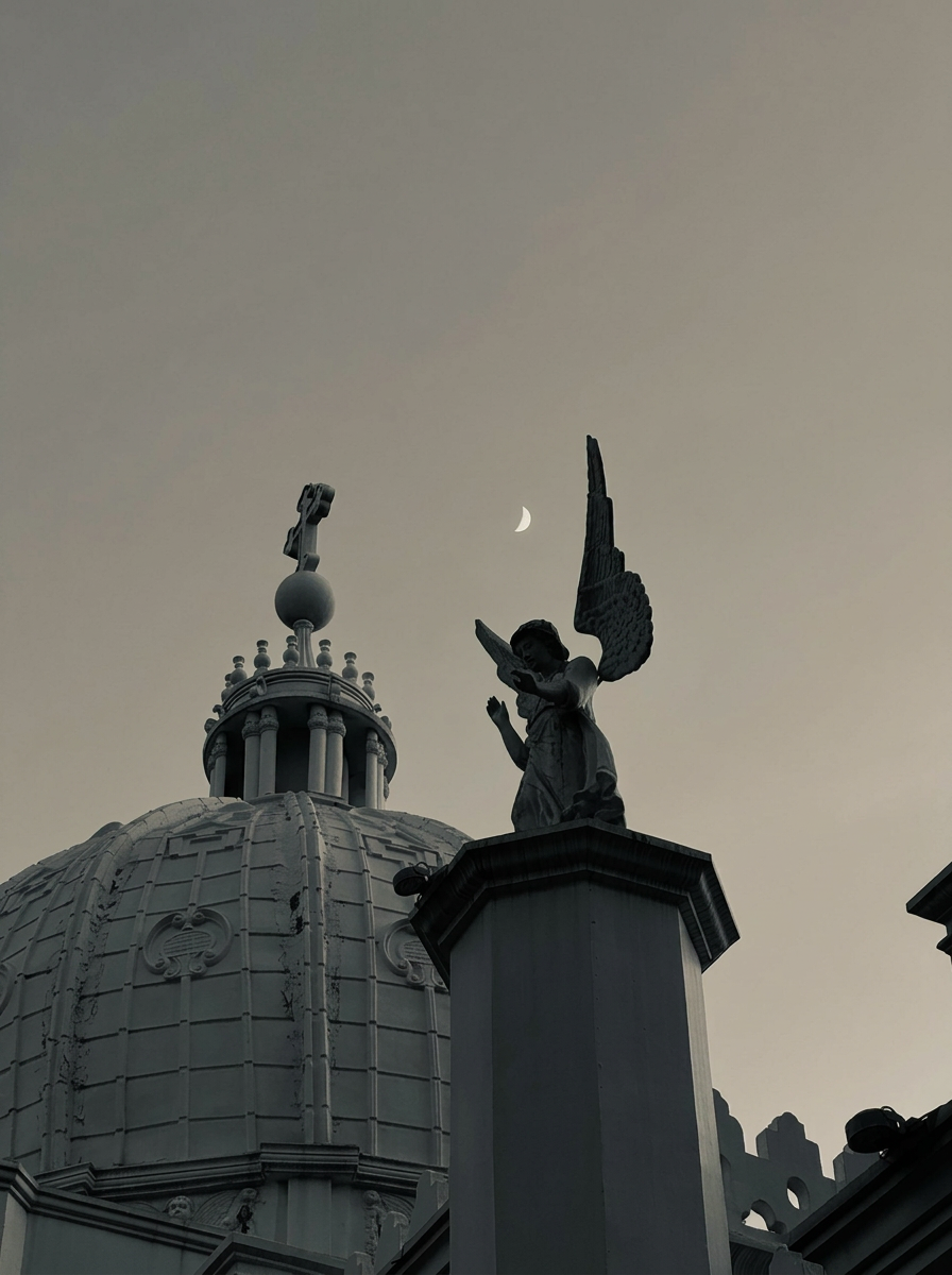 Dome and angel statue at dusk with a crescent moon